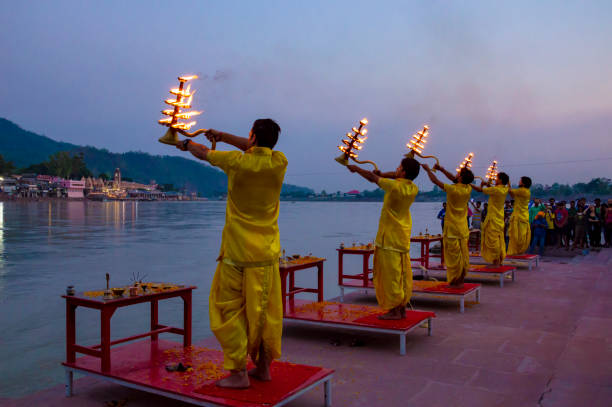 Rishikesh, Uttarakhand, India - June 1, 2017: Ganga Aarti begins every day at sunset at Rishikesh. An aarti is a devotional ritual that uses fire as an offering. It's usually made in the form of a lit lamp, and in the case of the Ganges River, a small diya with a candle and flowers that's floated down the river. The offering is made to the Goddess Ganga, also affectionately referred to as Maa Ganga, goddess of the holiest river in India.